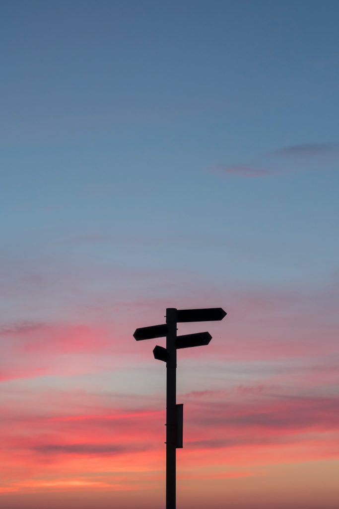 crossroads sign with sunset in background